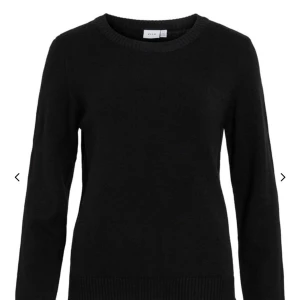 Svart stickad tröja från Vila - En klassisk svart stickad tröja från Vila med rund halsringning och långa ärmar. Perfekt basplagg som passar till det mesta och är enkel att styla. Ribbstickade muddar vid ärmslut och nederkant.