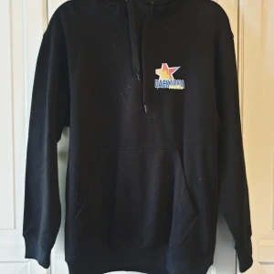 Hoodie Dackarna  - Svart hoodie i längre modell från Dackarna Målilla, logotyp på bröstet.  Hoodien har en känguruficka fram och dragsko i huvan.  Storlek XS-M  Oanvänd!   Se gärna mina andra annonser, samfraktar!