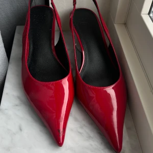 Röda klackar med spetsig tå - Snygga röda klackar från asos i lackmaterial. Skorna har en spetsig tå, öppen häl med rem och låg klack. Perfekta för utekväll, sommar och vardag❤️