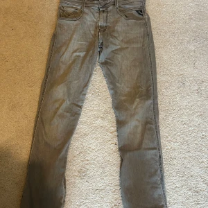 Replay grå jeans herr 29/32 - Snygga grå jeans från Replay i klassisk femficksmodell. Jeansen har raka ben, normal passform och coola detaljer på bakfickorna. Tillverkade i mjukt bomullsmaterial med en lätt tvättad look. Perfekta för dig som gillar stilrena och bekväma jeans. Skick 9/10