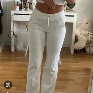 Juicy Couture vita byxor  - Snygga vita mjukisbyxor med hög midja och raka ben. Byxorna har snörning i midjan, stora fickor framtill och en bakficka med lock. Perfekta för en chill och avslappnad stil.