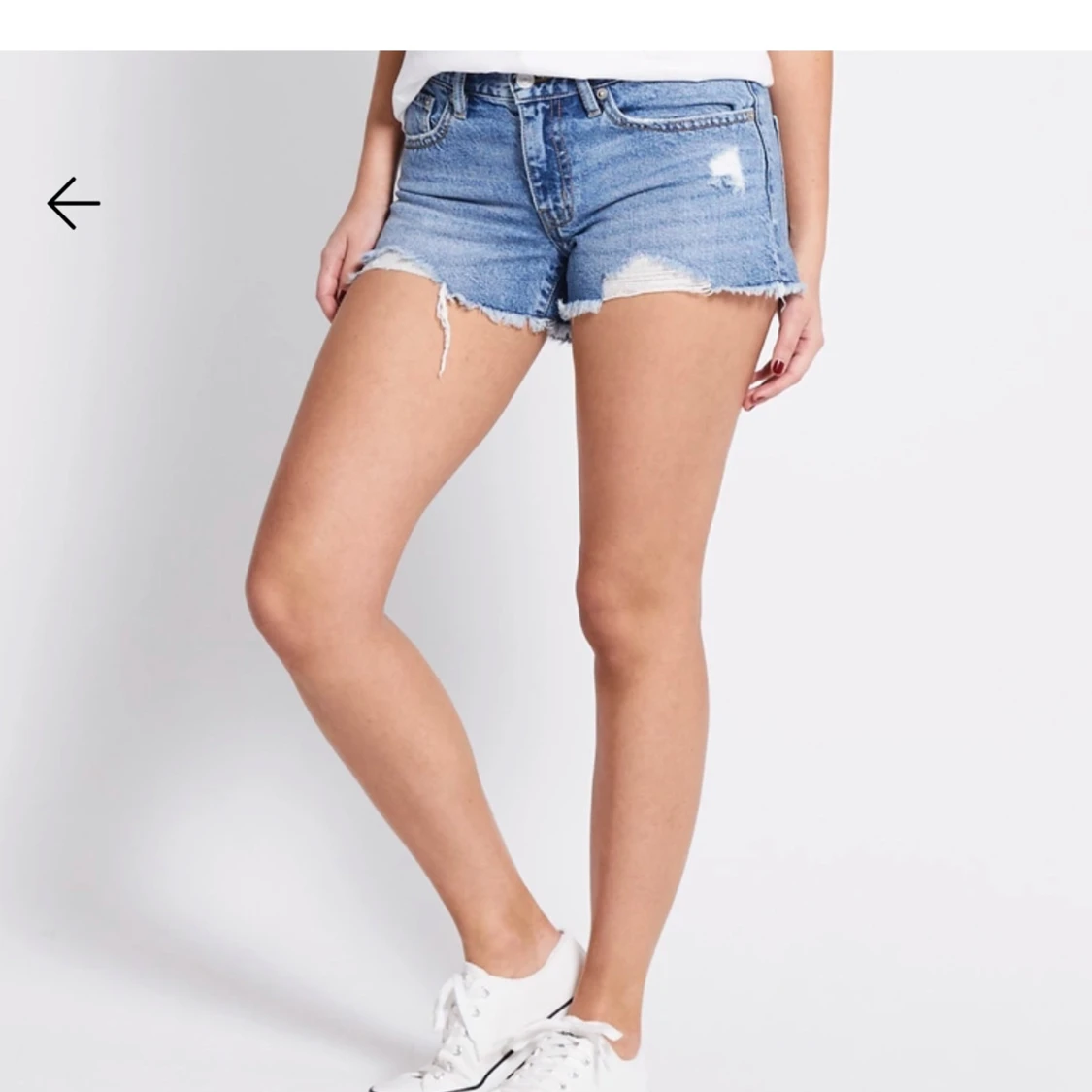 Blå jeansshorts med slitningar 