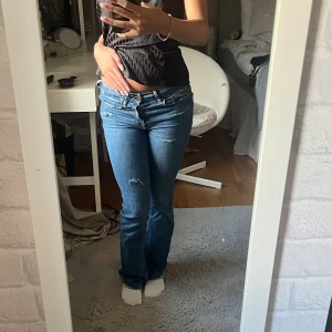 Blå bootcut jeans från Zara - säljer blåa lågmidjade bootcut jeans från zara med hål och lite slitna designer på framsidan🌺