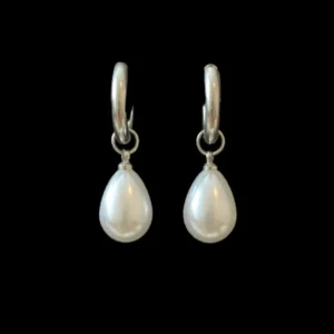 Silvriga örhängen med droppformad pärla - Stilrena örhängen i silverfärg med droppformade vita pärlor som hänger från små hoops. Perfekta för att ge en classy touch till din look. Enkla att matcha och ger en elegant vibe.