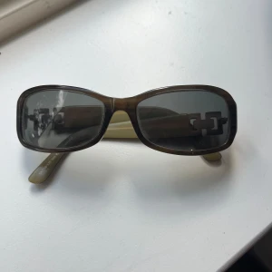  rektangulära solglasögon med metall-detalj - Snygga solglasögon med rektangulära bågar och mörka glas. 