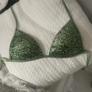 Grön glittrig bikini  - Jätte snygg grön glittrig bikini från Calzedonia. Köptes för länge sedan bara blivit använd 2 gånger då den är för liten. Passar någon med B-C kupa. 