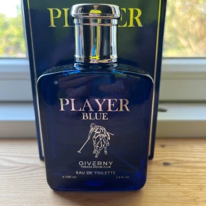 Player Blue Eau de Toilette 100ml - Player Blue från Giverny är en Eau de Toilette i en stilren, djupblå glasflaska med silverfärgad kork. Flaskan rymmer 100 ml och har en sportig design med en polospelare i guldtryck på framsidan. Kommer i matchande blå kartong med guldiga detaljer.