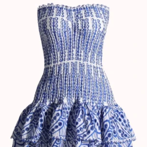 Blåvit axelbandslös volangklänning - Superfin kort axelbandslös klänning i blått och vitt med smockad överdel och volangig kjol. Klänningen har ett unikt mönster och är perfekt för varma dagar. Sitter tajt upptill och har en luftig kjol med flera lager volanger. Han inte slicka tillbaka då den inte passade mig så den har prislapp och är i original packeteringen.