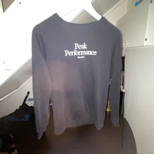Svart Peak Performance sweatshirt - Svart sweatshirt från Peak Performance med vit logga tryckt på bröstet. Enkel och stilren design som funkar till det mesta.