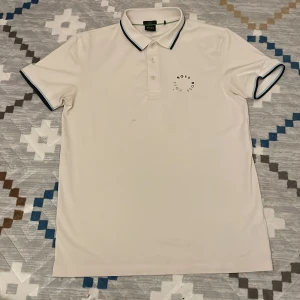 Boss pikétröja vit  - Säljer en riktigt fin boss pikétröja i storlek S. Skick 7/10. Nypris: 899kr (köpte när den hade rabbit) så kommer inte ihåg ordinarie pris. Mitt pris: 299 kr. Har en fläck (se sista bild) och boss loggan har rivits av, annars inga andra skador 