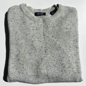 Stickad tröja Scotch & Soda - Säljer en grå stickad tröja med blå prickar från Scotch and Soda. Mycket bra skick och kvalitet. 