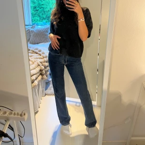 Mid straight jeans blå - Säljer ett par blå jeans med medelhög midja och raka ben. Klassisk femficksmodell med dragkedja och knapp framtill. Jeansen har en snygg mörkblå tvätt och är perfekta för dig som gillar en avslappnad och tidlös look.