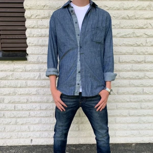 Blå mönstrad Hugo Boss skjorta, storlek S - Snygg blå Hugo Boss skjorta med små vita prickar, klassisk krage och bröstficka. Skjortan har långa ärmar som kan vikas upp för en mer avslappnad look. Tillverkad i bomull och stängs med knappar framtill. Perfekt för dig som gillar stilren men ändå chill stil. Priset är inte hugget i sten!