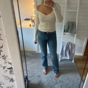 Blå raka jeans med hög midja - Säljer ett par klassiska blå jeans med medelhög midja och raka ben. Jeansen har en tidlös passform och är tillverkade i ett robust denimtyg. Perfekta för dig som gillar en enkel och clean look.