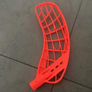 Innebandyblad Oxdog - Bilderna visar ett innebandyblad i färgen orange perfekt för dig som vill uppgradera din klubba och sticka ut på planen. Bladet har en modern design med robusta ribbor för bra bollkontroll och skott. Passar både träning och match för unga och aktiva spelare.