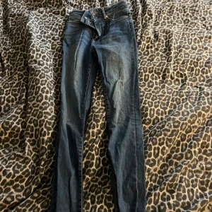Blå jeans med råa benslut, storlek S - Säljer ett par blå jeans i storlek S med snyggt slitna och råa benslut. Jeansen har klassisk femficksdesign och är i ett mjukt denimtyg som sitter skönt. Perfekta för dig som gillar en avslappnad och trendig look.
