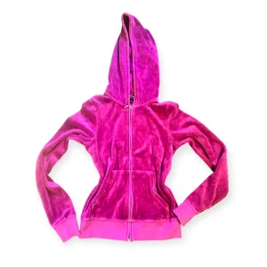 Juicy Couture lila velour hoodie S - Superglammig lila hoodie från Juicy Couture i mjuk velour med huva och dragkedja. Baksidan har ett stort guldigt emblem med strass och texten 'Glamorous Juicy Couture'. Perfekt för dig som vill sticka ut med en ikonisk 00-talsstil.