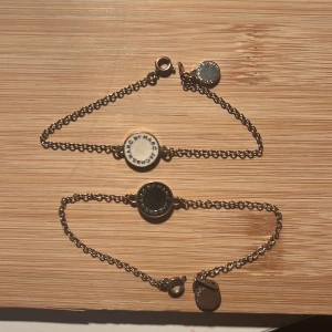 Marc by Marc Jacobs armband duo - Två snygga armband från Marc by Marc Jacobs med tunn kedja i silverfärg och rund bricka i mitten. 