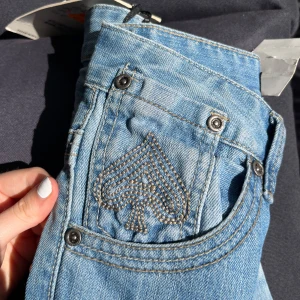 Ljusblåa lågmidjade bootcut jeans från Henryj & Jeans - Fina lågmidjade jeans med mycket broderade detaljer på alla fickor. Tyvärr för små/korta för mig (172 cm), är ganska korta i längden men super snygga. Svårt att säga hur de sitter nertill då de ej satt som de skulle på mig, men skulle säga mellan bootcut och raka. 