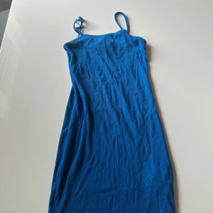 Blå ribbad klänning från Misu - Säljer en snygg blå ribbad klänning från Misu i storlek 36. Klänningen har smala axelband och ärmlös design, perfekt för varma dagar. Materialet är mjukt och stretchigt, vilket gör den bekväm att bära. Enkel och stilren look som är lätt att matcha med accessoarer.