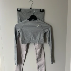 Grått kit från Gymshark  - Säljer ett par grå seamless leggings från Gymshark med hög midja och snygg ribbad detalj upptill storlek S. Säljes med matchande tröja i storlek xs