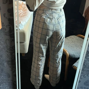 Rutiga byxor - Ljusa rutiga byxor som går lika bra att ha som pyjamas som till skolan <3 De är lite stora för mig, så jag håller upp dem för att passa rätt på bild 1 & 2! Knappen ha lossnat, men jag har lite olika knappar liggandes hemma så om det önskas kan jag sy på en ny innan jag skickar iväg dem :) Det är bara att fråga så kan jag skicka bild på de knappar jag har