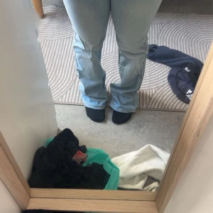 Ljusblå Lågmidjade bootcut jeans Blue Collection - Snygga ljusblå jeans från Blue Collection med klassisk femficksdesign och bootcut-ben. Jeansen har kontrastsömmar och en röd logotyp på bakfickan. Perfekta för dig som gillar en avslappnad och trendig look. Aldrig använt. Innerbenslängden 75cm och midjemått 34cm rakt över men tyget är stretchig💕