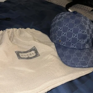 Blå Gucci keps med GG monogram  - Säljer en snygg blå keps från Gucci med det klassiska GG monogram över hela kepsen. Kepsen är i storlek M men är sjusterbar 