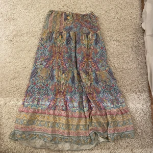 Trendig långkjol från Marta - Säljer en bohemisk långkjol från Marta med färgstarkt paisleymönster. Kjolen har resår i midjan och är tillverkad i ett lätt och luftigt material, resåren är något utstretchad (se bild) men sitter fortfarande som en s💗