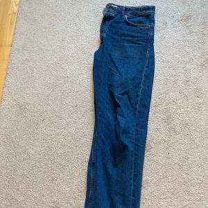 Blå jeans från Jack & Jones - Säljer ett par klassiska blå jeans från Jack & Jones med raka ben och normal passform. Jeansen har fem fickor, gylf med dragkedja och snygga kontrastsömmar. Perfekta till vardags och enkla att matcha med olika stilar. Säljes då de har en defekt under skrevet. Tveka inte på att höra av dig vid frågor eller funderingar! Mvh Sixten 