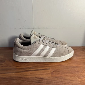 Gråa Adidas sneakers i mocka - Säljer ett par stilrena gråa Adidas sneakers i mocka. Skorna är i väldigt bra skick förutom ett litet håll på högra innersulan. Kan vid önskan skicka med en extra sula. 