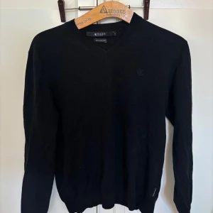 Tiger of Sweden svart tröja, storlek S - Svart V-ringad tröja från Tiger of Sweden. Har några år på nacken. Det finns ett litet hål på en av ärmarna och en liten fläck på framsidan, i övrigt fint skick. Märkt S men sitter som en XS/S, troligen åt slim fit-hållet.