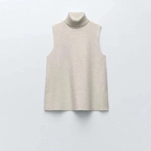 Beige ärmlös polotopp Zara - Stilren beige ärmlös topp med polokrage från Zara. Perfekt att styla över en skjorta eller bära som den är. Enkel och tidlös design med rak passform. 