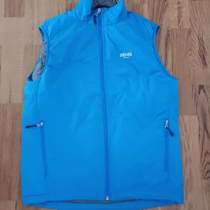 Blå quiltad väst från 8848 Altitude - Snygg blå väst från 8848 Altitude med dragkedja framtill och två fickor med dragkedja. Västen är quiltad på insidan och har en hög krage. Perfekt för lager-på-lager under kyliga dagar. Helt ny. Kan sänka priset vid snabb affär.