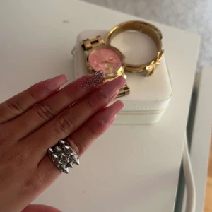 Silvrig ring med nitar - Cool och edgy silvrig ring med flera små nitar i ett rutmönster. Perfekt accessoar för att ge din outfit en tuffare känsla. Ringen är bred och i metall.