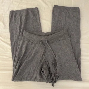 Grå mjukisbyxor från Gina Tricot - Mysiga grå stickade mjukisbyxor från Gina Tricot i strl S, med bred ribbad midja och snöre. Dom är mid waist och har breda ben. Super skönt mjukt material. 