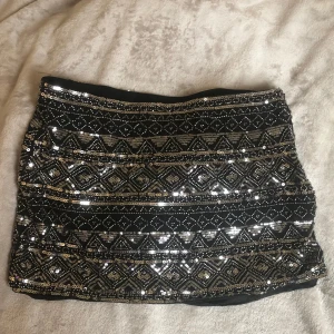 Svart paljettkjol från Zara - Säljer en svart kortkjol från Zara med glittriga paljetter i silver och mönster. Dragkedja i sidan för enkel påklädning. Andvänt dessa två eller tre gånger men de är lite för tajt för min smak. Nypris = 450kr 💕