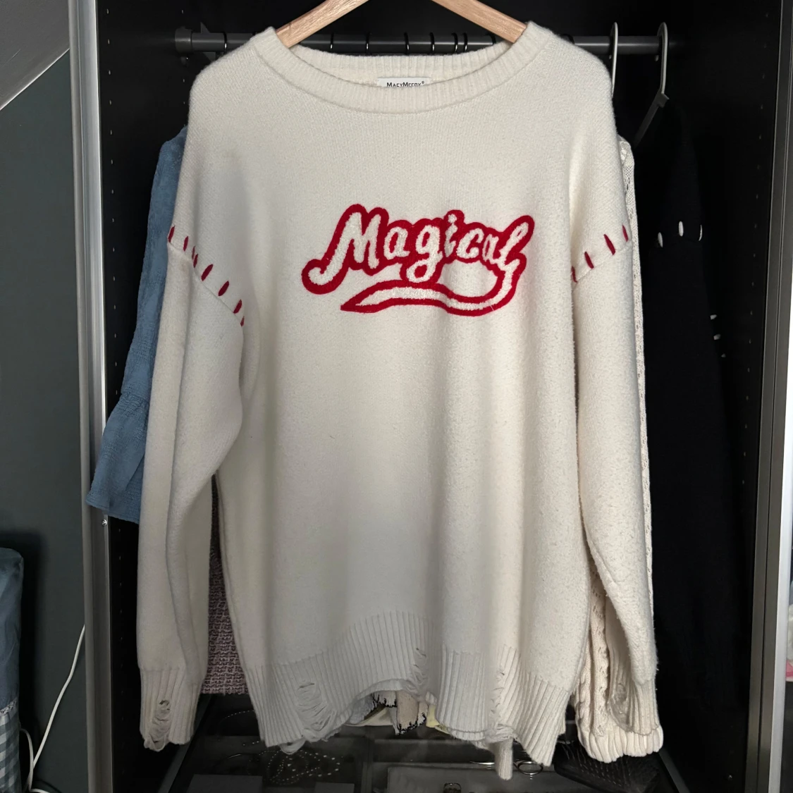 Vit stickad tröja med röd text från MacyMccoy