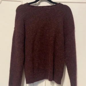 Vinröd stickad tröja från Cubus - Mysig vinröd stickad tröja från Cubus med lång ärm och enkel, klassisk design. Tröjan har en fluffig yta och rund halsringning, perfekt för kyliga dagar.