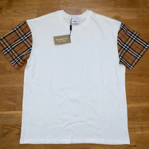 Burberry t-shirt - Säljer en vit t-shirt från Burberry som är oanvänd i storlek XL. T-shirten har rund halsringning och är tillverkad i mjuk bomull. Priset kan diskuteras. Svarar på alla frågor!