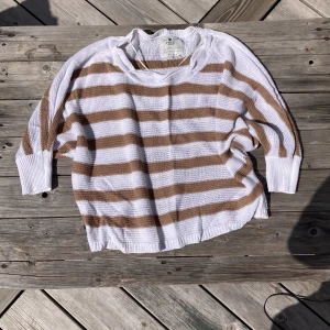 Randig stickad tröja från Pulz Jeans - Säljer en stickad tröja från Pulz Jeans i vitt och beige med breda horisontella ränder. Tröjan har lång ärm, rund halsringning och en avslappnad passform. Perfekt för lager-på-lager och snygg till jeans eller kjol.