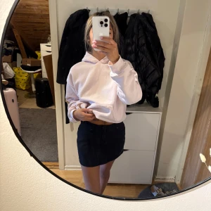 Svart jeanskjol - Säljer en svart jeanskjol med klassisk femficksdesign och dragkedja framtill. Kjolen är kort och har en rak passform som passar till många olika stilar. Perfekt för dig som gillar en enkel och stilren look.