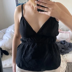 Svart linnetopp med v-ringning - Säljer en svart linnetopp med djup v-ringning med smala axelband. Toppen har använts en gång, perfekt för varma dagar🤍