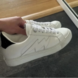  Zadig & Voltaire skor - Intressekoll på mina snygga vita sneakers från Zadig & Voltaire med svart hälparti och vit blixtdetalj på sidan. Dom är i stl 38, vill kanske sälja då jag knappt använder dom längre🥰