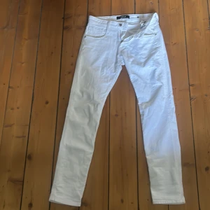 Vita jeansbyxor från Replay Anbass - Säljer ett par vita Replay Anbass jeans med klassisk femficksdesign. Byxorna har snygga detaljer som Replay-logga på bakfickan och patch vid linningen. Perfekta för dig som vill ha en clean och stilren look. Priset är ej hugget i sten! 🪨 
