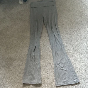 Grå yoga pants från Gina Tricot - Säljer ett par grå leggings från Gina Tricot i storlek XS. Byxorna har bootcut-modell med hög midja och är gjorda i mjukt bomullsmaterial. Perfekta för en avslappnad och trendig look.