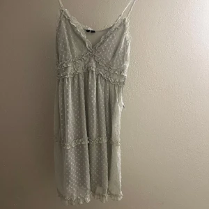 Vit prickig klänning från Vero Moda - Klänningen har en v-ringad design och smala axelband