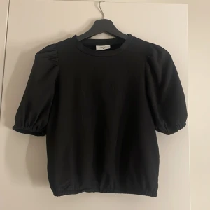 Svart topp från Grunt - Svart topp från Grunt med puffiga ärmar. Säljer pga att jag aldrig använder den längre