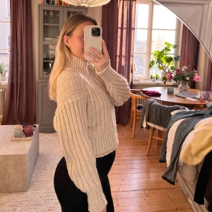 Beige stickad tröja - Säljer en mysig beige stickad tröja med hög krage. Tröjan har långa ärmar och en ribbad design som ger en stilren look. Perfekt för kyligare dagar!