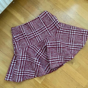 Rutig kjol från NA-KD - Snygg rutig kjol i vinrött och vitt från NA-KD. Kjolen har en klassisk passform och är perfekt för att ge en stilren look. Den är fodrad för extra komfort och har en härlig struktur i materialet.